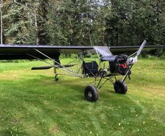 a small airplane sitting on top of a lush green field