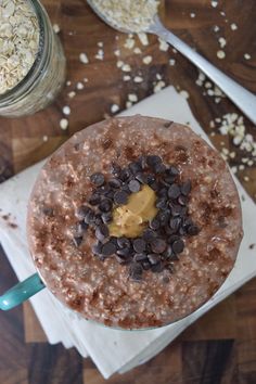 a chocolate smoothie with peanut butter on top and oats in the background, ready to be eaten