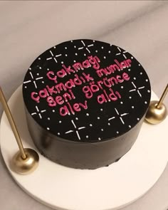 a black and white cake with pink writing on it