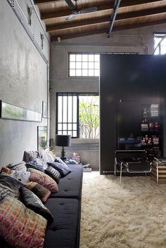 a living room filled with lots of furniture and pillows on top of a white rug