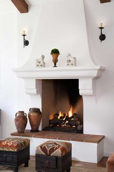 a living room filled with furniture and a fire place next to a wall mounted fireplace