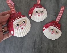 two handmade christmas ornaments are being held by someone's hands on the floor