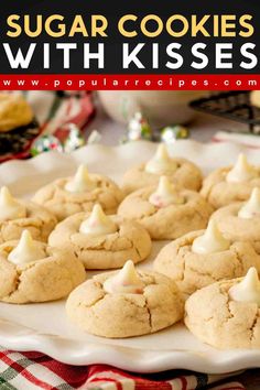 sugar cookies with kisses on a white platter next to other cookies and candy canes