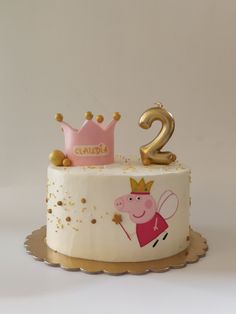 a two year old birthday cake with pep the pig on top and gold numbers 2