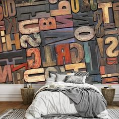 a bed sitting in front of a wall covered in letters