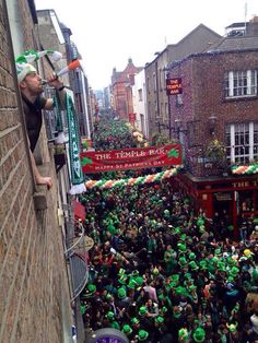 a large group of people standing on the side of a building