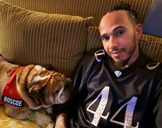 a man sitting on a couch next to a dog