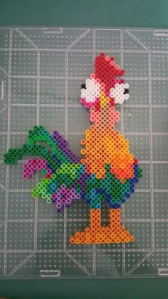 a chicken made out of perler beads on top of a piece of plastic sheet