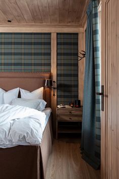 a bedroom with wood paneling and plaid wallpaper on the walls, along with a bed