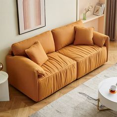 a living room with an orange couch and coffee table on the floor next to it