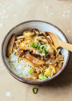 a bowl filled with rice and meat on top of a table