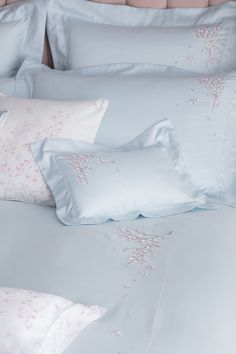 a bed with blue sheets and pink pillows