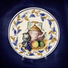 Vintage Hand-Painted Spanish Pottery Wall Plate. 10" Spanish pottery wall plate with hand-painted still life featuring a teapot and fruits. Signed on the front by the artist. Impressed on the underside with maker's stamp. There is a hanger on the back for display. In excellent condition with chips or cracks. Please feel free to message me with any questions. I have and strive to keep 100% happy buyers. Spanish Pottery, Pottery Wall, Painting Still Life, Wall Plate, Serving Plates, Plates On Wall, Still Life, Tea Pots, The Artist