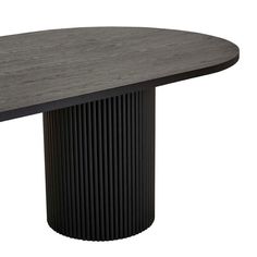 an oval dining table with a black base and wooden grained top, viewed from the front