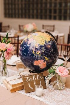 a table topped with a globe and flowers