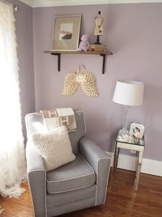 a living room filled with furniture and a lamp on top of a hard wood floor