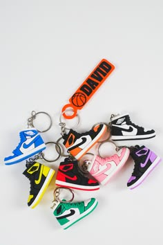 four pairs of nike sneakers are shown with keychains in the shape of shoes