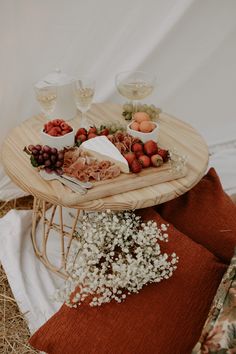 a tray with grapes, strawberries and other fruits on it sitting on a chair