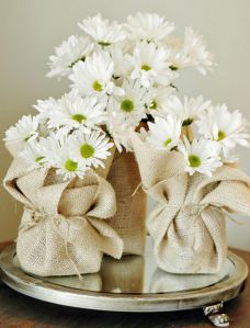 white daisies in a burlock wrapped vase on a tray with twine bows