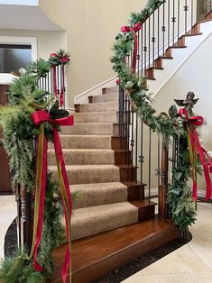 the stairs are decorated with christmas garland and bows