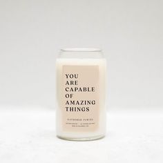 a candle that says you are capable of amazing things in front of a white background