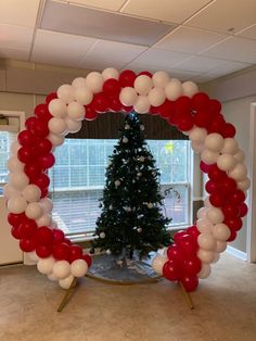 a decorated christmas tree with red, white and silver balloons in the shape of a circle