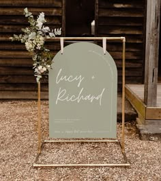 a sign with flowers on it sitting in front of a wooden structure that says lucky richard