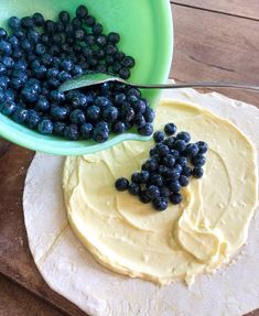 blueberries are being spread on top of dough