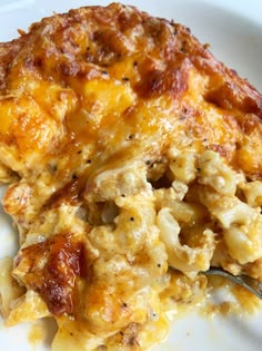 a white plate topped with macaroni and cheese casserole covered in sauce