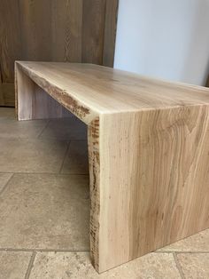 a wooden bench sitting on top of a tile floor