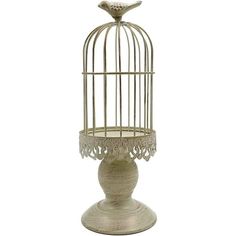 a bird in a cage on top of a white stand with a candle holder underneath it