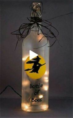 a bottle that has some lights in it and is decorated with a witch on top