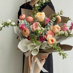 a woman holding a bouquet of flowers in her hands