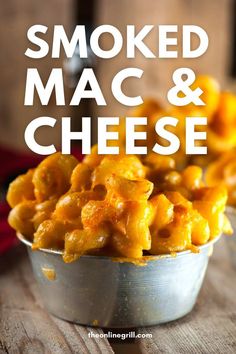 a metal bowl filled with macaroni and cheese on top of a wooden table