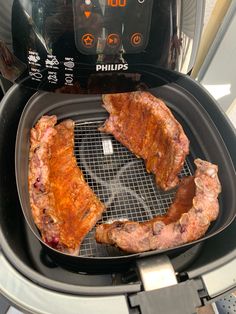 two pieces of meat are being cooked in an air fryer with the timer on