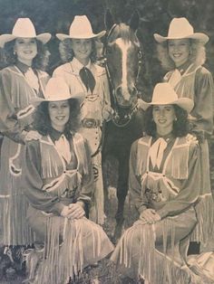 an old black and white photo of women in western garb sitting next to a horse