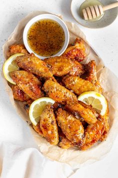 chicken wings with lemon wedges and dipping sauce