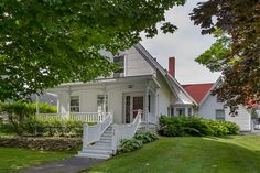 a white house sitting on top of a lush green field