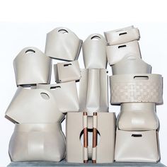 a bunch of white objects stacked on top of each other in front of a white wall