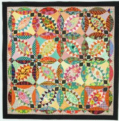 a colorful quilt is hanging on the wall