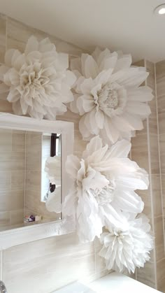 large white paper flowers are hanging on the wall