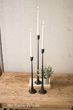 three candles are sitting on a wooden table