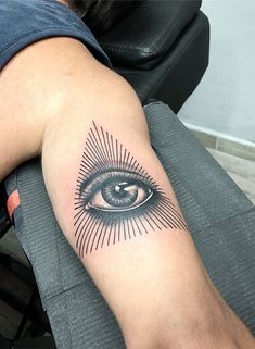 a person with a tattoo on their arm that has an eye in the middle of it