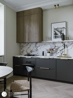 a modern kitchen with marble counter tops and black cabinets, along with wooden flooring