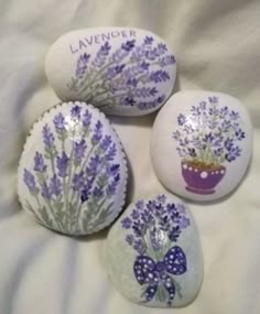 four painted rocks with lavender flowers on them