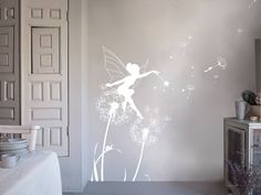 a bedroom with a dandelion wall decal in the shape of a fairy