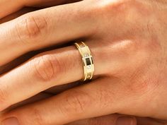 a person's hand with a gold ring on their left and a diamond in the middle