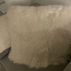 a white fluffy pillow sitting on top of a bed