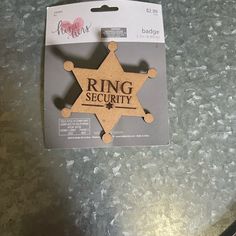 a badge with the word ring security on it sitting on top of a metal table