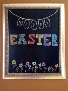 a chalkboard with the words happy easter written on it in front of a string of flowers